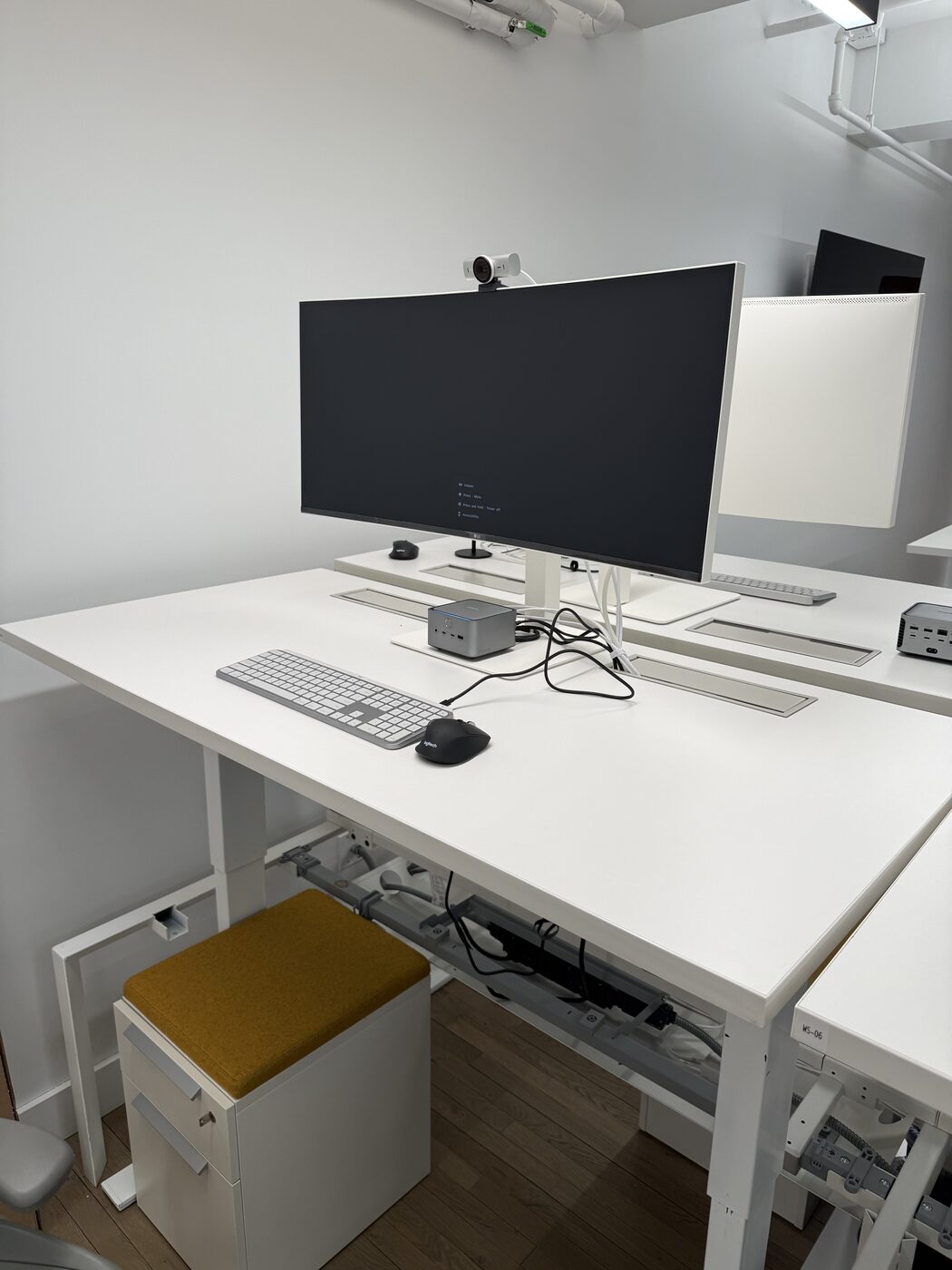 Finished standing desk with ultrawide monitor, webcam, and compact desktop